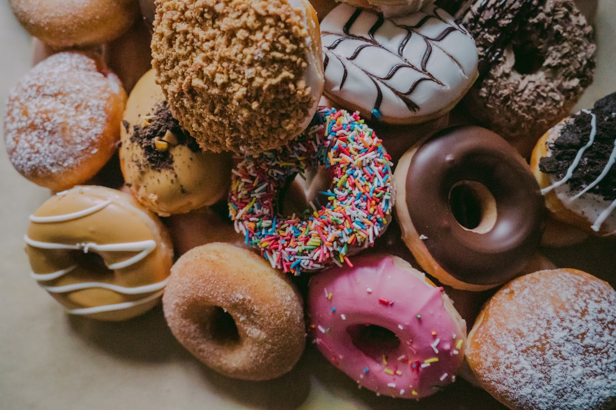 Assorted decorated birthday donuts laid out edge to edge
