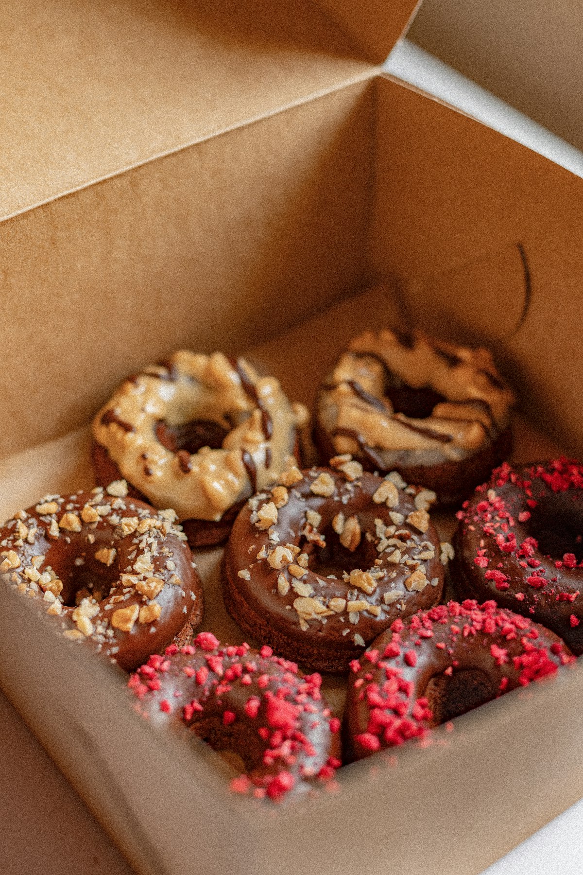 Box of chocolate and pink decorated donuts for spelling out a name